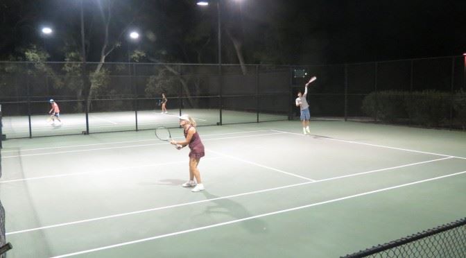 Adults Playing Tennis in the Evening